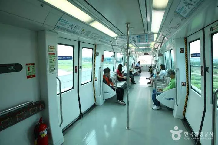 Interior de un vagón del Metro de Seúl con pasajeros y asientos prioritarios para seniors.